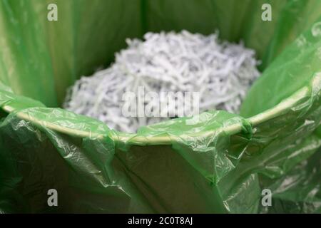 Un dettaglio di documenti nazionali e documenti cartacei triturato in un bidone di carta straccia rivestito di una borsa di polietilene verde, una precauzione contro il furto di identità e per garantire la protezione dei propri dati personali dalle frodi, il 12 giugno 2020, a Londra, Inghilterra. Foto Stock