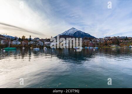 Vista panoramica mozzafiato del villaggio di Spiez con la neve coperta Niederhorn delle Alpi svizzere sull'Oberland Bernese in background, dal lato del lago Thun o Foto Stock