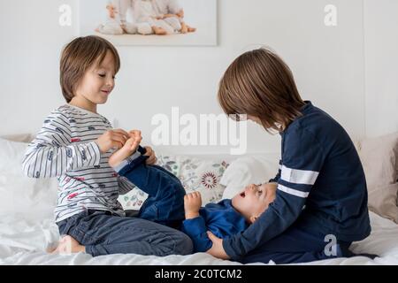 Bambini, fratelli, giocare a casa, piedi solletico ridendo e sorridendo Foto Stock