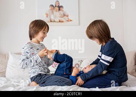 Bambini, fratelli, giocare a casa, piedi solletico ridendo e sorridendo Foto Stock