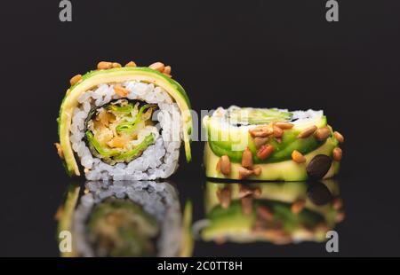 Sushi roll su fondo in vetro nero. Vista frontale del cibo tradizionale Giapponese Asiatico Foto Stock
