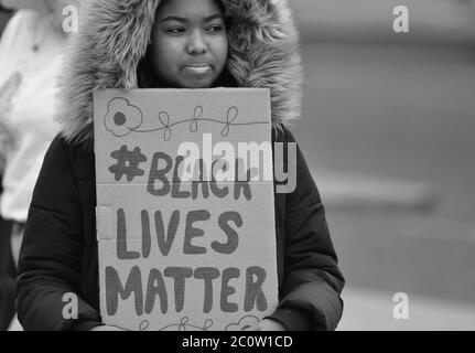 Una giovane donna nera che tiene un segno di materia di vite nero n. Come frequenta una protesta BLM nel Regno Unito in 2020 Foto Stock