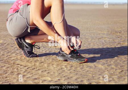 Giovane donna runner che legano le scarpe Foto Stock