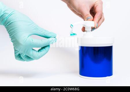 Concetti di prodotto di cura della pelle e procedura di bellezza. Pompa a pressione manuale per donne di flacone in plastica con gel per la cura del viso, primo piano, fondo bianco. Foto Stock