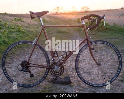 Una classica bicicletta da corsa su un sentiero in ghiaia in campagna. Foto Stock