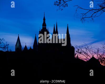 La silhouette delle torri del Castello di Praga e della Cattedrale di San Vito contrasta con il cielo blu al crepuscolo, Repubblica Ceca Foto Stock