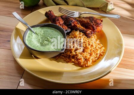 Cosce di pollo peruviane con salsa coriandolo verde aji verde e riso fritto Foto Stock