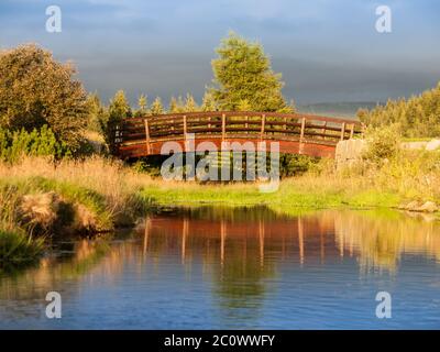 Sera paesaggio di montagna. Ponte di legno sul fiume tranquillo. Montagne di Jizera, Repubblica Ceca Foto Stock