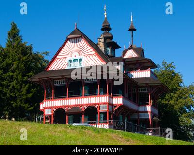 Pittoresco cottage in legno di montagna di Mamenka in stile architettonico secessione popolare slavo sulla soleggiata giornata estiva, Pustevny, Beskids, aka Beskydy Mountains, Moravia, Repubblica Ceca. Foto Stock