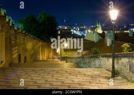 Nuova strada per le scale del castello che conduce al Castello di Praga Repubblica Ceca illuminata da lampioni di strada con una splendida vista su Praga durante la notte Foto Stock