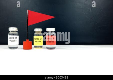 Più flaconcini di vaccino di covid-19 e un allarme rosso. Concetto vincitore di gara e concorso per lo sviluppo del vaccino coronavirus. Foto Stock