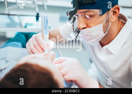 Riempimento dei denti - l'applicazione della resina - il riempimento si indurisce dopo l'esposizione alla luce UV, questo li rende molto durevoli Foto Stock