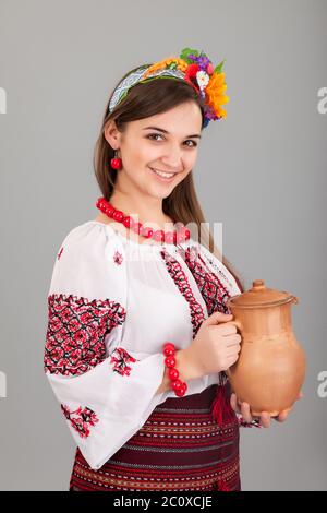 Attraente donna indossa ucraino è in possesso di una brocca vestito nazionale Foto Stock