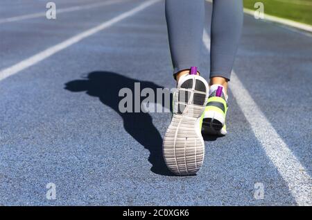 Atleta runner piedi giù pista dello stadio. Jogging, sport, sano stile di vita attivo concetto Foto Stock