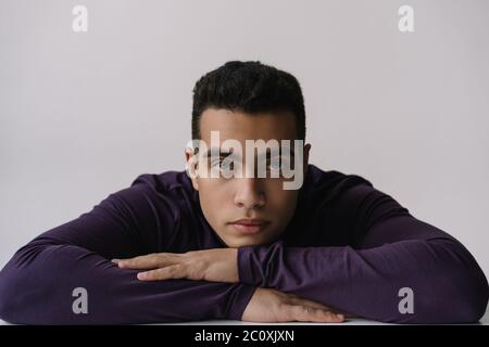 Ritratto di serio attore afroamericano che posa per le immagini in studio isolato su sfondo. Modello con design a dolcevita che si affaccia sulla fotocamera Foto Stock