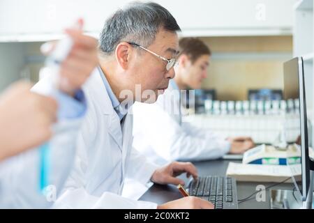 Persone che fanno di esperimento di chimica in laboratorio moderno Foto Stock