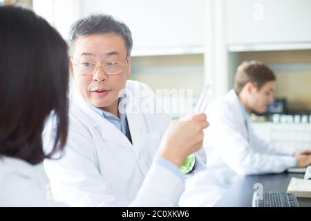 Persone che fanno di esperimento di chimica in laboratorio moderno Foto Stock