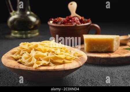 Preparazione alla cottura della pasta con pomodori secchi e parmigiano. Cucina italiana, ingredienti Foto Stock