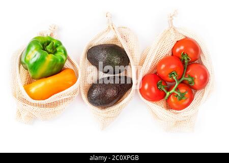 Pomodori, pepe, avocado in sacchetto di tessuto a rete. Borsa ecologica con verdure biologiche Foto Stock