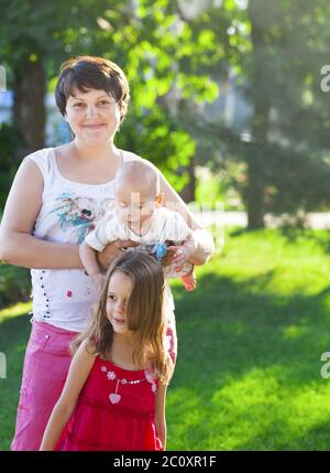 Madre e i suoi figli all'aperto. Mamma felice e i suoi bambini che giocano insieme nel parco Foto Stock