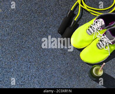 Scarpe da running, corda da salto e bottiglia da bere con succo verde Foto  stock - Alamy