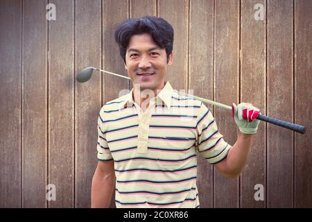 Immagine composita del golfista e permanente tenendo il suo club sorridente in telecamera Foto Stock