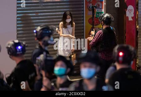 Hong Kong, Cina. 12 giugno 2020. I cittadini interagiscono con la polizia durante una ricerca della polizia durante un rally nel distretto di Mongkok di Hong Kong il 12 giugno 2020. Migliaia di Hong Kongers hanno cantato inno di protesta e hanno cantato slogan in tutta la città il 12 giugno, in quanto hanno segnato l'anniversario di un anno di scontri importanti tra la polizia e dimostranti pro-democrazia. Credit: May James/ZUMA Wire/Alamy Live News Foto Stock