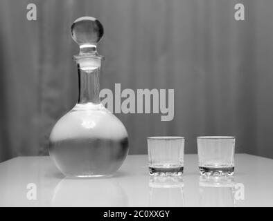 Decanter e due bicchieri con vodka in piedi sul tavolo Foto Stock