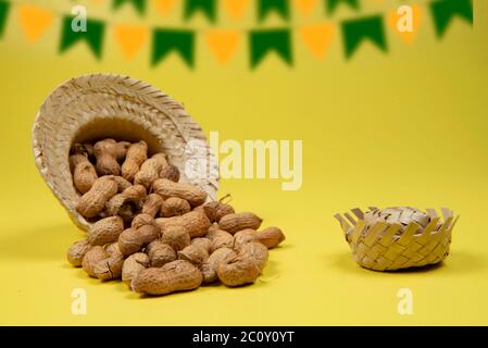 mucchio di arachidi in guscio su sfondo giallo. Tipico pizzico di festa di giugno (Festa Junina) Foto Stock