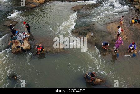 Tangerang meridionale, Indonesia. 12 giugno 2020. (NOTA DELL'EDITORE: Immagine presa con un drone)residenti che pescano nel flusso di Kali Angke al sito Lengkong Wetan, Serpong un'alternativa per i residenti di viaggiare localmente in mezzo all'implementazione in corso di restrizioni sociali su larga scala (PSBB) a Tangerang per sopprimere la diffusione del coronavirus (Covid-19). Credit: SOPA Images Limited/Alamy Live News Foto Stock