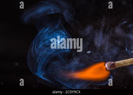 Match con fumo e fuoco su sfondo nero copyspace Foto Stock