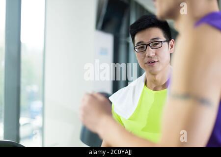 Giovani asiatici persone che lavorano in una palestra moderna Foto Stock