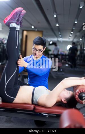 Giovani asiatici persone che lavorano in una palestra moderna Foto Stock