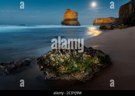 Il giorno si innalba dopo una notte di luna piena alla famosa Great Ocean Road. Foto Stock