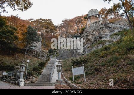 Tempio di Golgulsa Scala della Corea del Sud su una roccia che conduce a una statua di buddha scolpita in una montagna Foto Stock