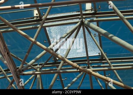 Vista dal basso della moderna tetto di vetro nel quartiere degli affari in serata con il vetro rotto Foto Stock