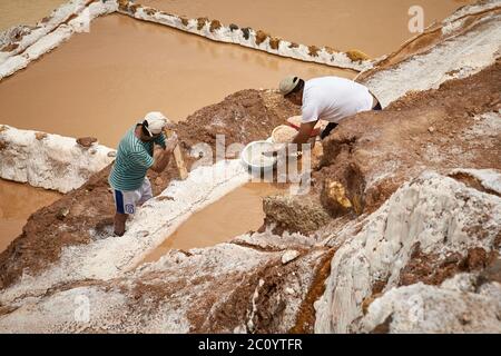 Lavoratori a salina de Maras, il tradizionale campo di sale inca a Maras vicino Cuzco in Valle Sacra per Foto Stock