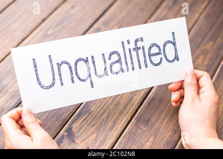 donna tiene carta con parola non qualificata in ufficio Foto Stock