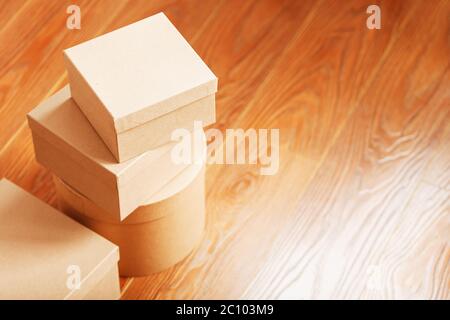 Scatole di cartoni sul pavimento in legno di forme diverse. Foto Stock