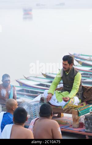 Sacerdote indù che esegue rituali religiosi sulla riva del fiume Gange a Varanasi, India. Una delle città più antiche del mondo e importante luogo di pellegrinaggio per Foto Stock