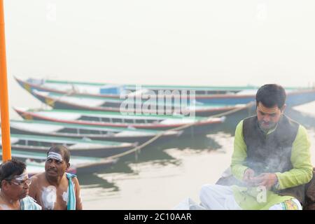 Sacerdote indù che esegue rituali religiosi sulla riva del fiume Gange a Varanasi, India. Una delle città più antiche del mondo e importante luogo di pellegrinaggio per Foto Stock