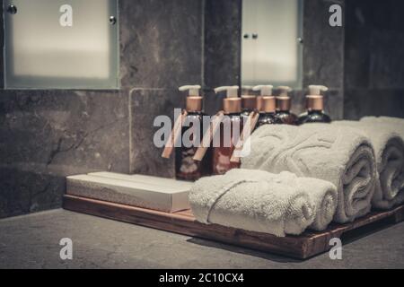 Pila di asciugamani in bagno con dosatore per sapone liquido e spazzolini da denti closeup Foto Stock