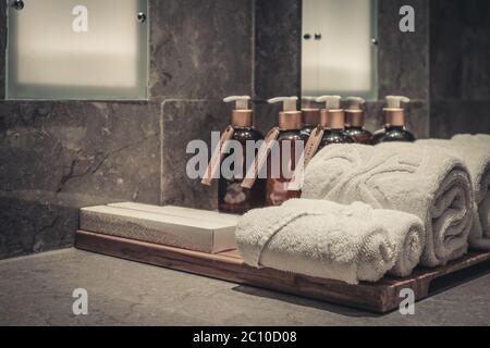 Pila di asciugamani in bagno con dosatore per sapone liquido e spazzolini da denti closeup Foto Stock