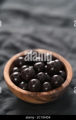 drage al cioccolato con nocciole in ciotola di legno d'oliva Foto Stock