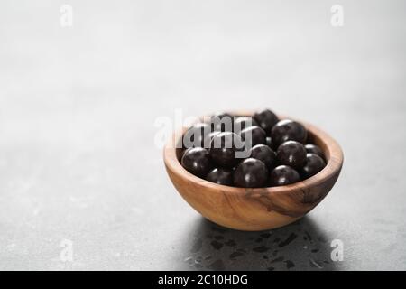 drage al cioccolato con nocciole in ciotola di legno d'oliva Foto Stock