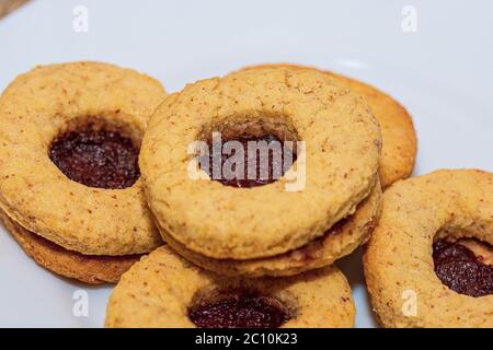 Un mazzo di biscotti Linzer soffici riempiti con confettura di fragole dolci Foto Stock