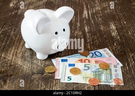 Salvadanaio con banconote e monete in euro. Foto Stock