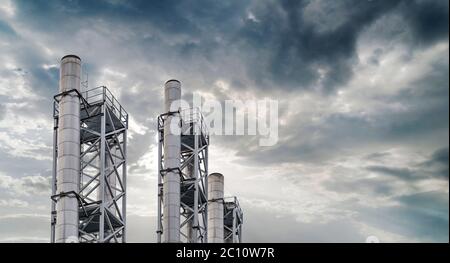 Zona industriale e acciaio numerosi condotti con cielo nuvoloso drammatico Foto Stock