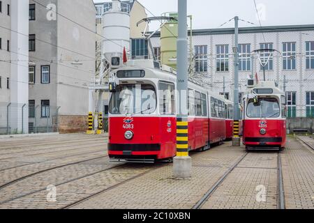 Due tram rossi articolati Vienna 4083 e 4085, costruiti negli anni '70 ancora in uso, parcheggiati in un deposito di tram, Vienna, Austria. Foto Stock