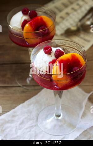 Gelato di pesche e salsa di lamponi dessert dedicata alla Australian cantante lirica Melba. Stile rustico. Foto Stock